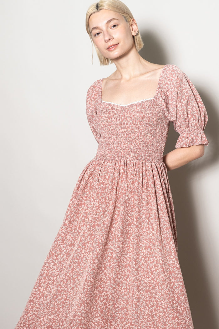 woman wearing a pink floral puff sleeve dress with a square neckline and fitted bodice