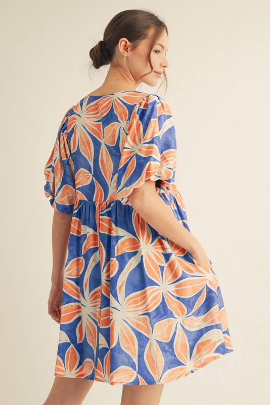 woman wearing a blue floral print dress with puff sleeves and a flared skirt