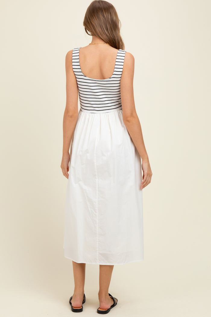 woman wearing a striped maternity dress with a white skirt, showcasing a visible baby bump from the back