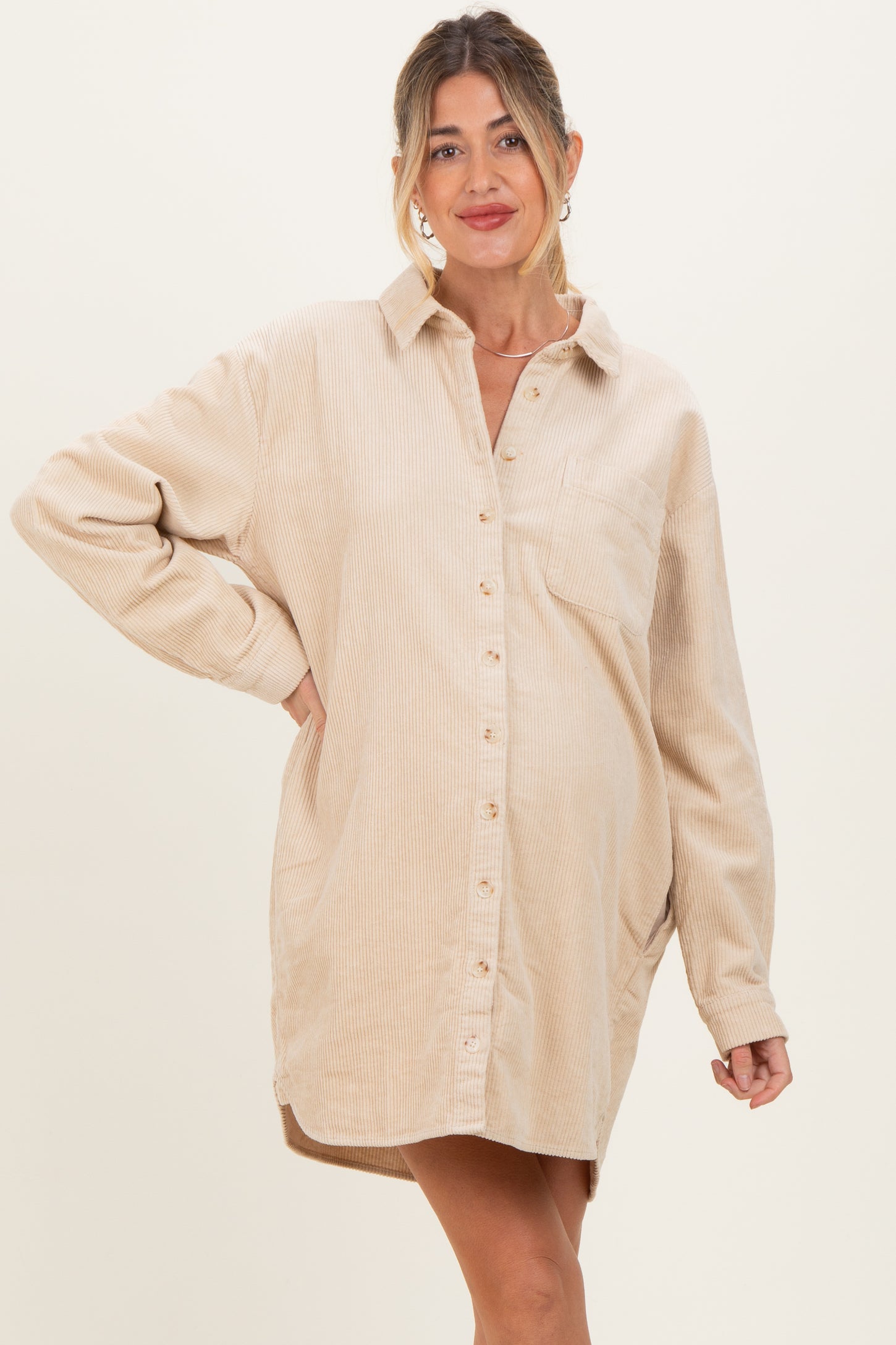 woman wearing a beige corduroy maternity shirt dress with a collar and button-down front, showing her baby bump