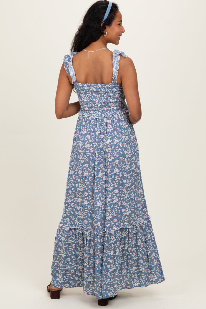 woman wearing a blue floral maternity maxi dress with ruffled straps and a flowy skirt, showing her back