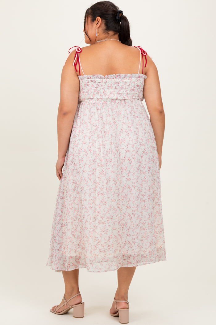 woman wearing a back view of a white floral midi dress with pink straps and a smocked bodice in women's plus size