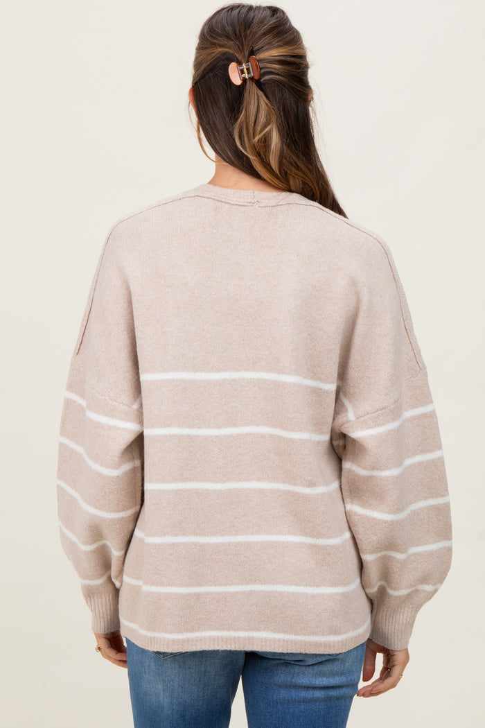 woman wearing a light beige striped maternity sweater with balloon sleeves, shown from the back