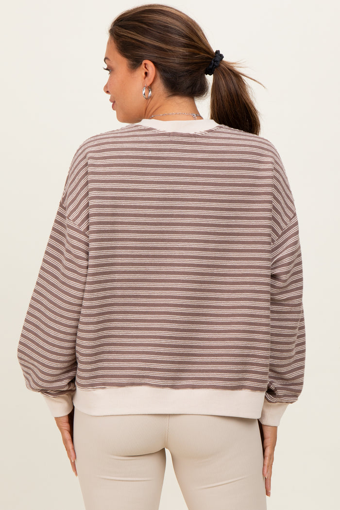 woman wearing a striped beige and brown maternity sweatshirt with a relaxed fit and balloon sleeves
