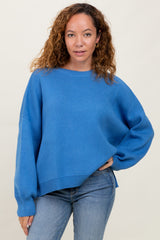 woman wearing a bright blue oversized knit sweater with long sleeves and a relaxed fit paired with light blue jeans
