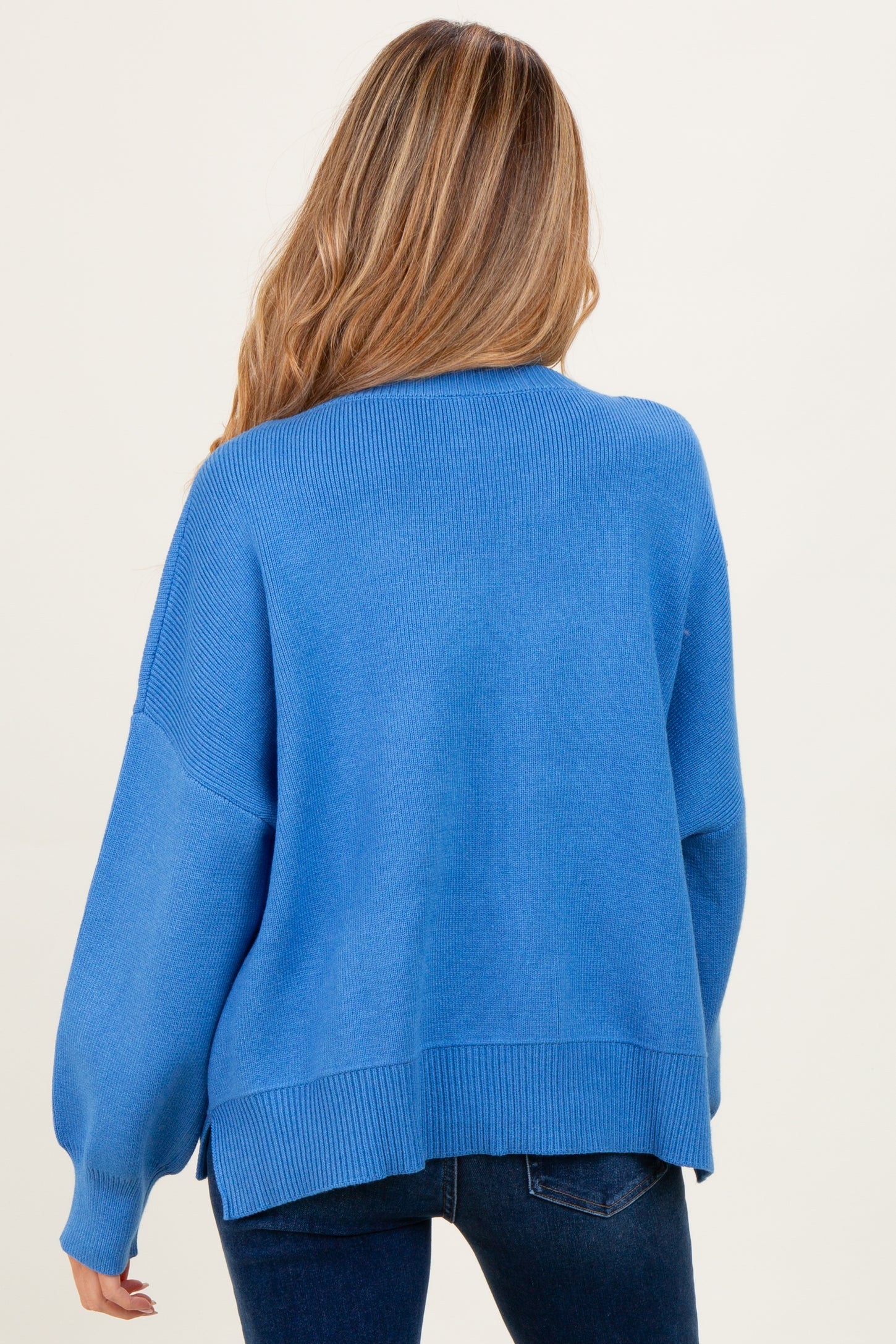woman wearing a soft blue oversized maternity sweater with long sleeves and a relaxed fit