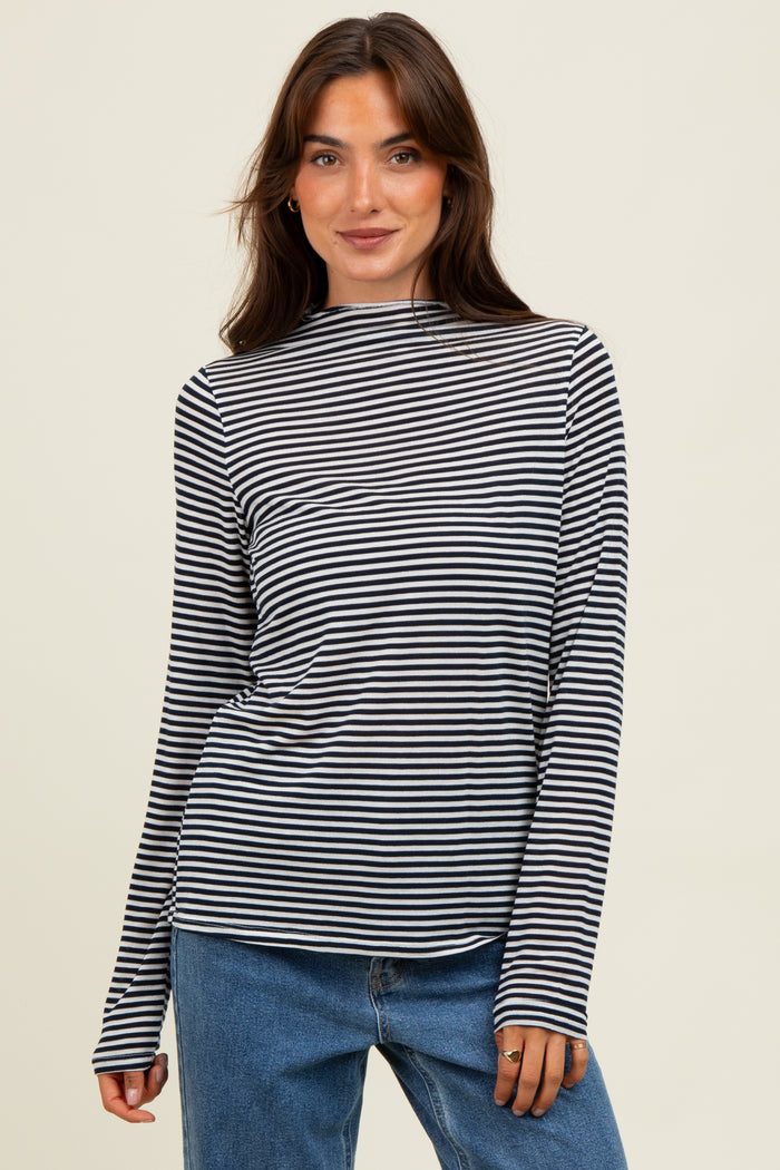 woman wearing a black and white striped long sleeve top paired with blue jeans