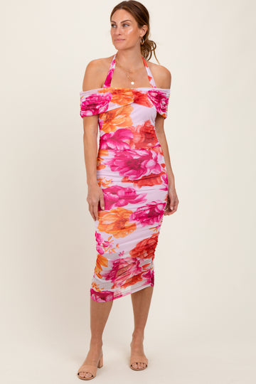 woman wearing a pink floral halter neck mid-length dress with off-the-shoulder sleeves and a fitted silhouette