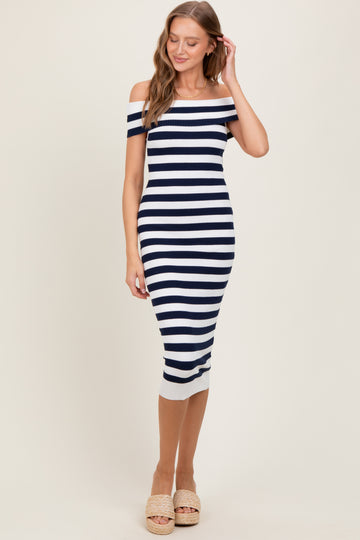 woman wearing a fitted navy and white striped off-the-shoulder dress with a ribbed hem and espadrille sandals