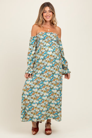 woman wearing a floral off-the-shoulder maternity maxi dress with long sleeves and a visible baby bump