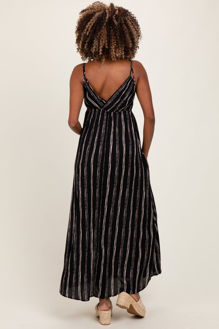 woman wearing a black and white striped maternity maxi dress with a crisscross back design