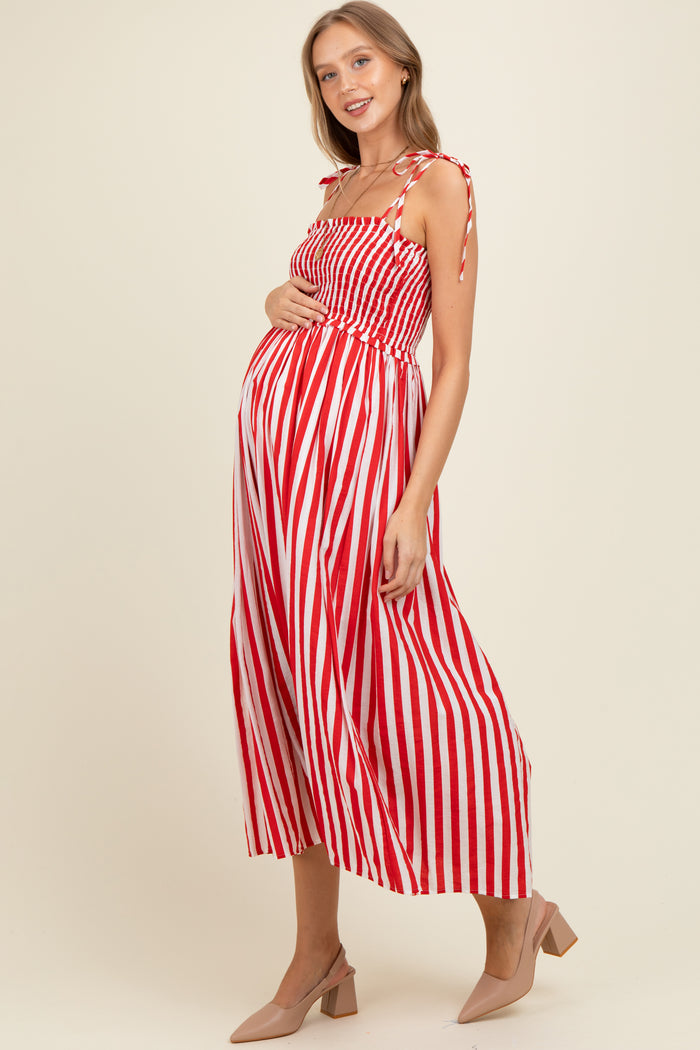 woman wearing a red and white striped maternity dress with tie straps and a visible baby bump