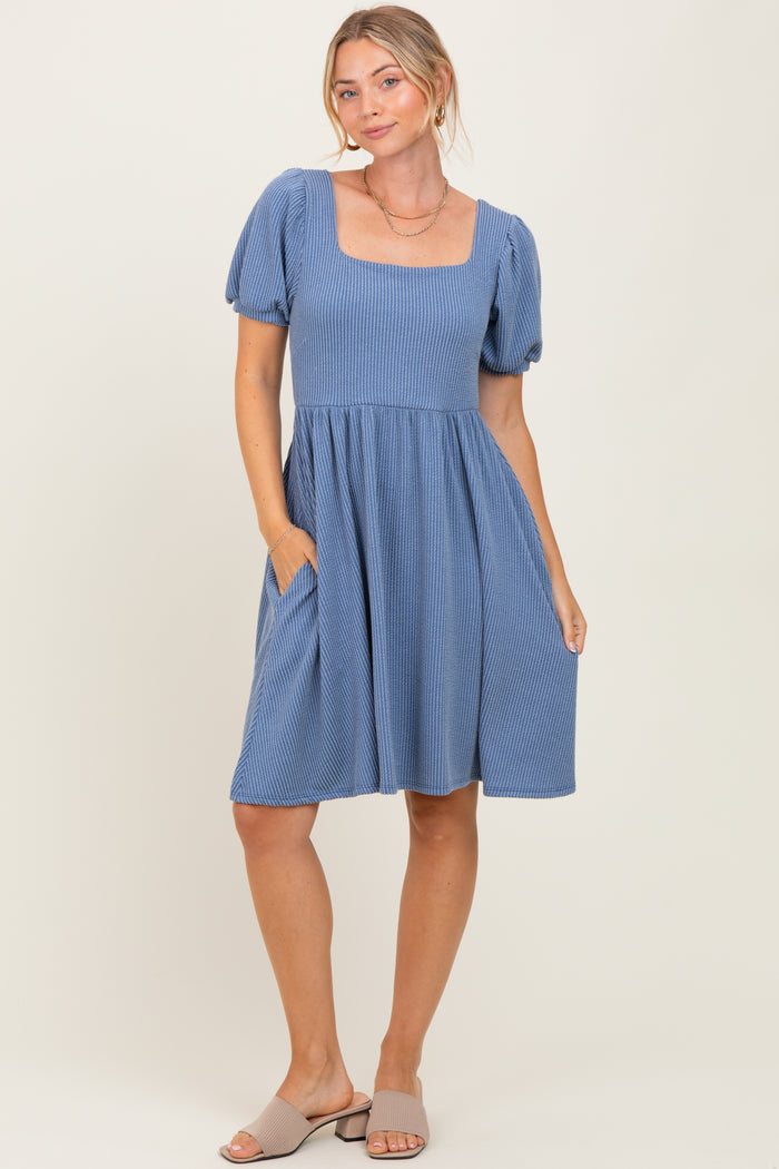 woman wearing a blue striped short sleeve dress with a square neckline and pockets