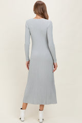 woman wearing a light gray ribbed maternity dress with long sleeves, showing back view and ankle-length silhouette