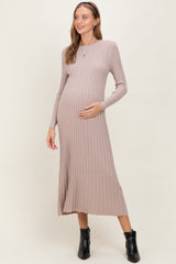woman wearing a taupe ribbed long sleeve maternity dress and holding her baby bump