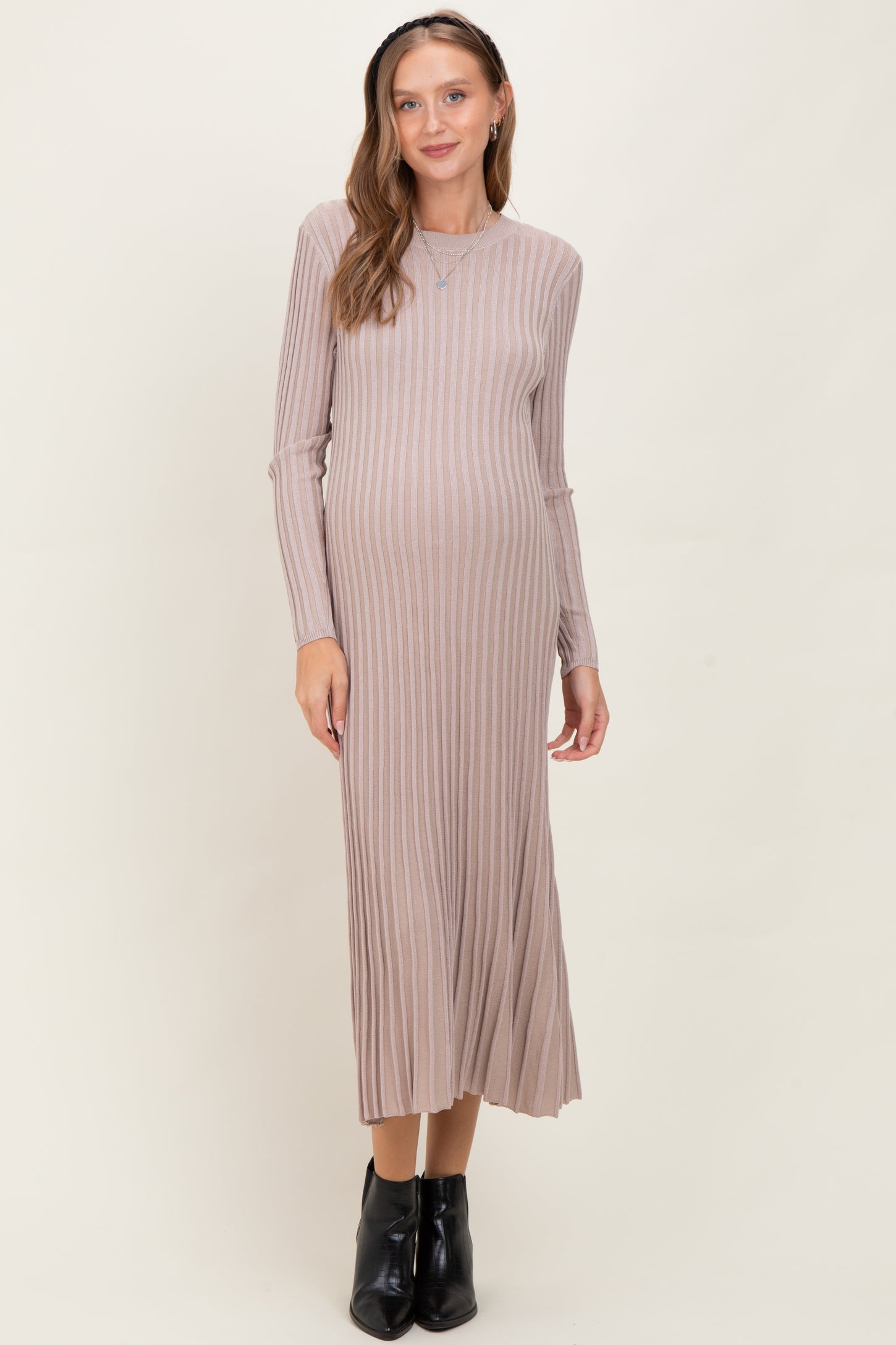 woman wearing a light brown ribbed maternity dress with long sleeves and a visible baby bump