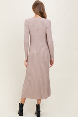 woman wearing a ribbed long sleeve beige maternity dress, showcasing a fitted silhouette and mid-calf length