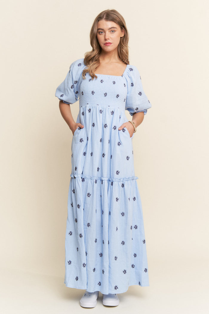 woman wearing a light blue floral maxi dress with puff sleeves and pockets