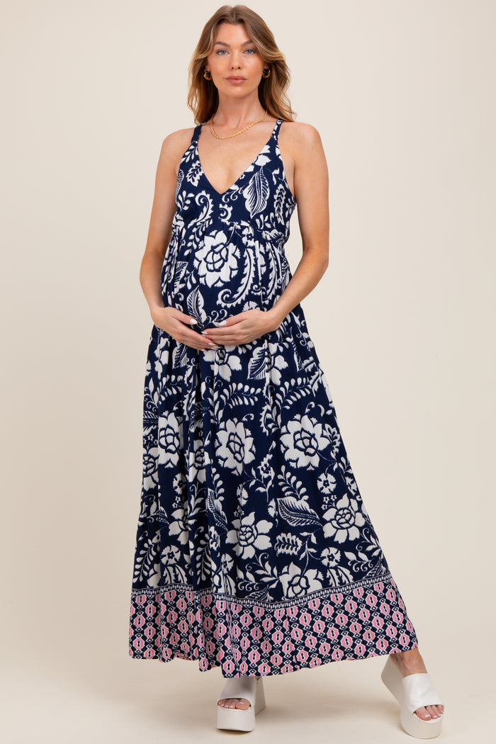 woman wearing a navy blue maternity maxi dress with floral patterns and a visible baby bump