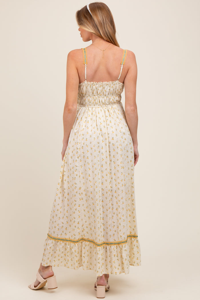 woman wearing a floral maternity maxi dress with a smocked back and adjustable straps, showing a baby bump