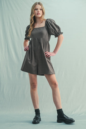 woman wearing a brown checkered puff sleeve mini dress with a square neckline and black platform shoes