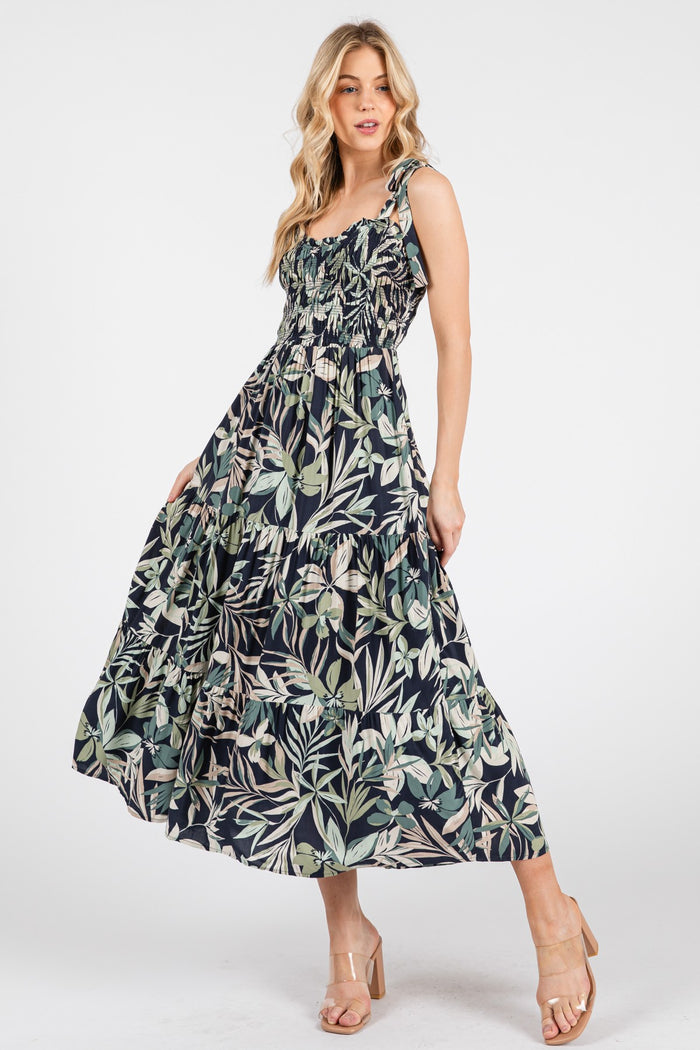 woman wearing a navy floral maxi dress with ruffled tiers and adjustable straps
