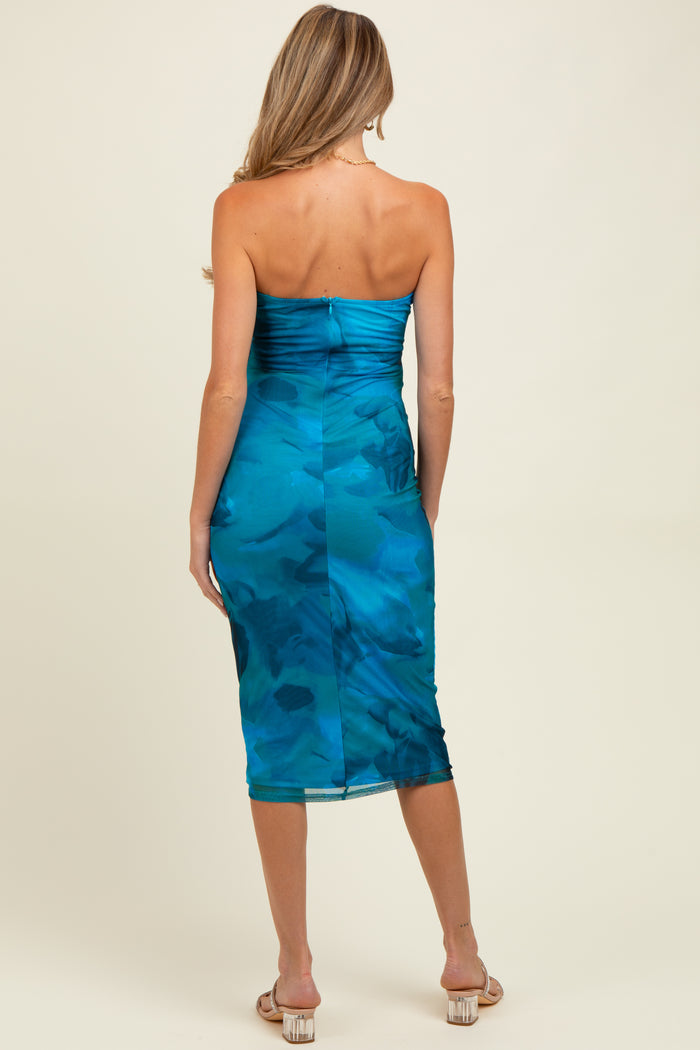 woman wearing a turquoise strapless midi maternity dress with a form-fitting silhouette and abstract pattern, showing a baby bump