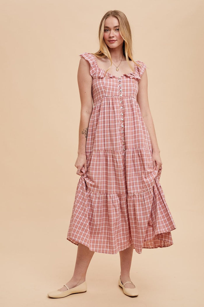 woman wearing a pink gingham tiered midi dress with ruffle sleeves and button details