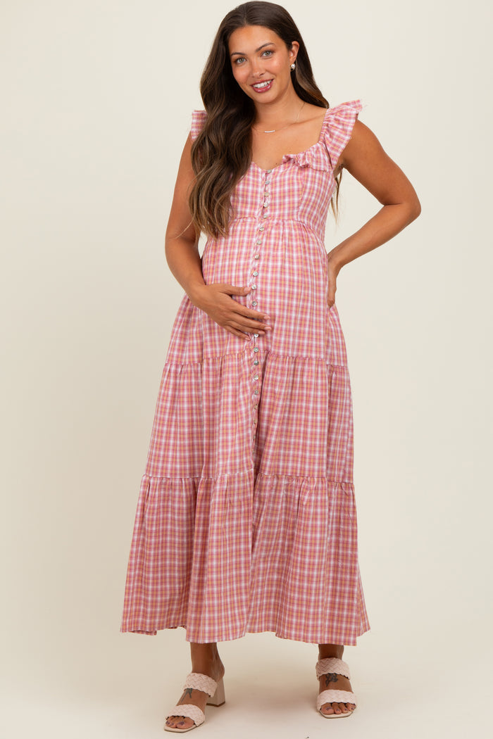 woman wearing a pink and white gingham maternity maxi dress with ruffle straps and a visible baby bump