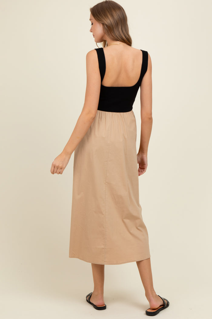 woman wearing a black and beige maternity dress with a fitted bodice and flowing skirt, showing her back