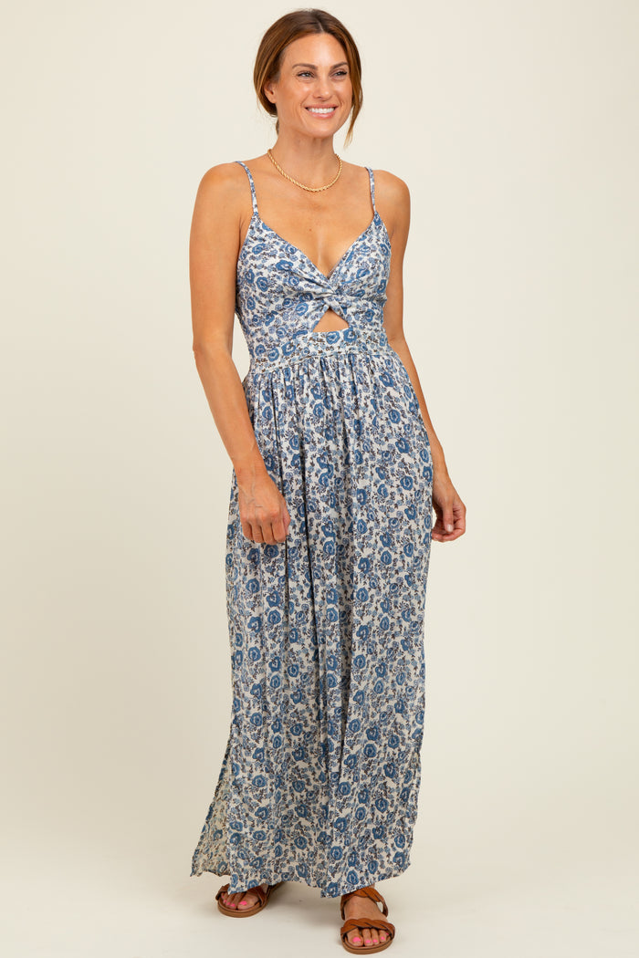 woman wearing a blue floral maxi dress with a twisted front detail and adjustable straps