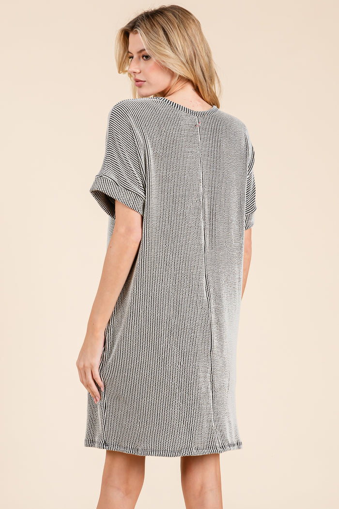 woman wearing a black and white striped short sleeve dress with a relaxed fit and back seam detail