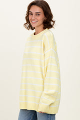 woman wearing a yellow and white striped oversized sweater and blue jeans