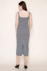 woman wearing a black and white gingham midi dress with a fitted silhouette and a back slit