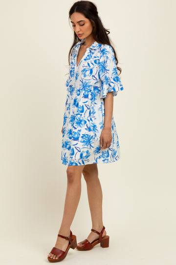 woman wearing a short-sleeve blue and white floral dress and brown heeled sandals