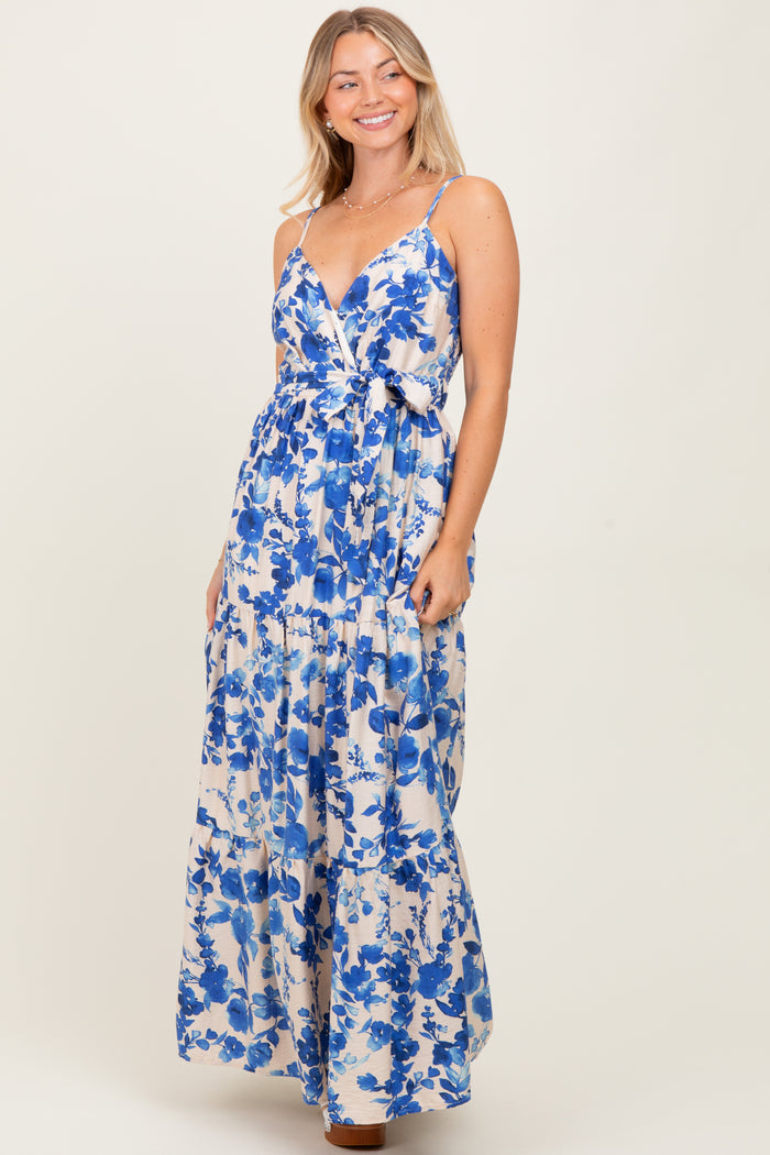 woman wearing a floral maxi dress in blue and white with a tie front and spaghetti straps