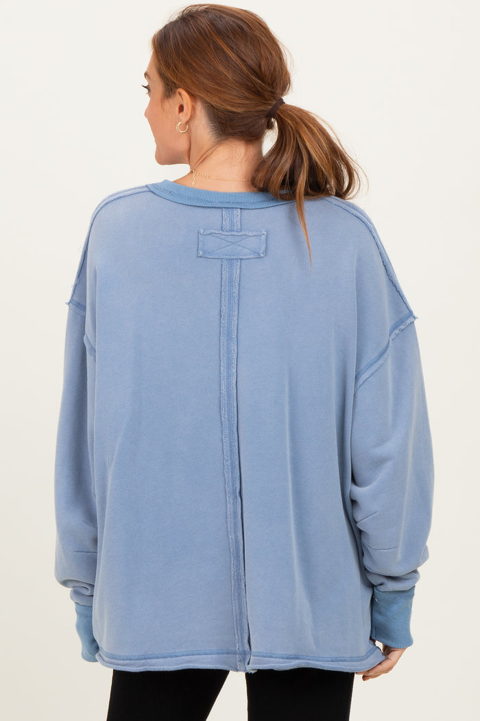 woman wearing a light blue oversized sweatshirt with a split back and dropped shoulders