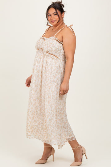 woman wearing a floral print plus size maxi dress with adjustable straps and a bow detail, paired with nude heels