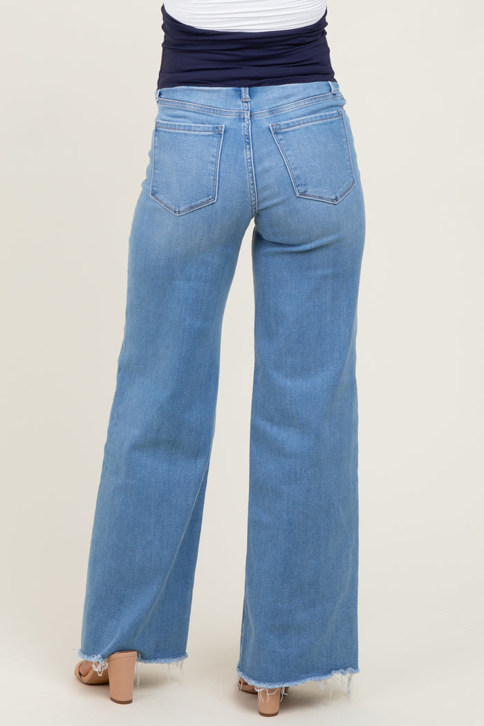 maternity wear light wash wide leg jeans with frayed hem, view of the back, model wearing them with a navy top