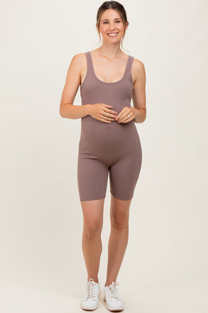 woman wearing a mauve ribbed maternity romper with a visible baby bump and white sneakers