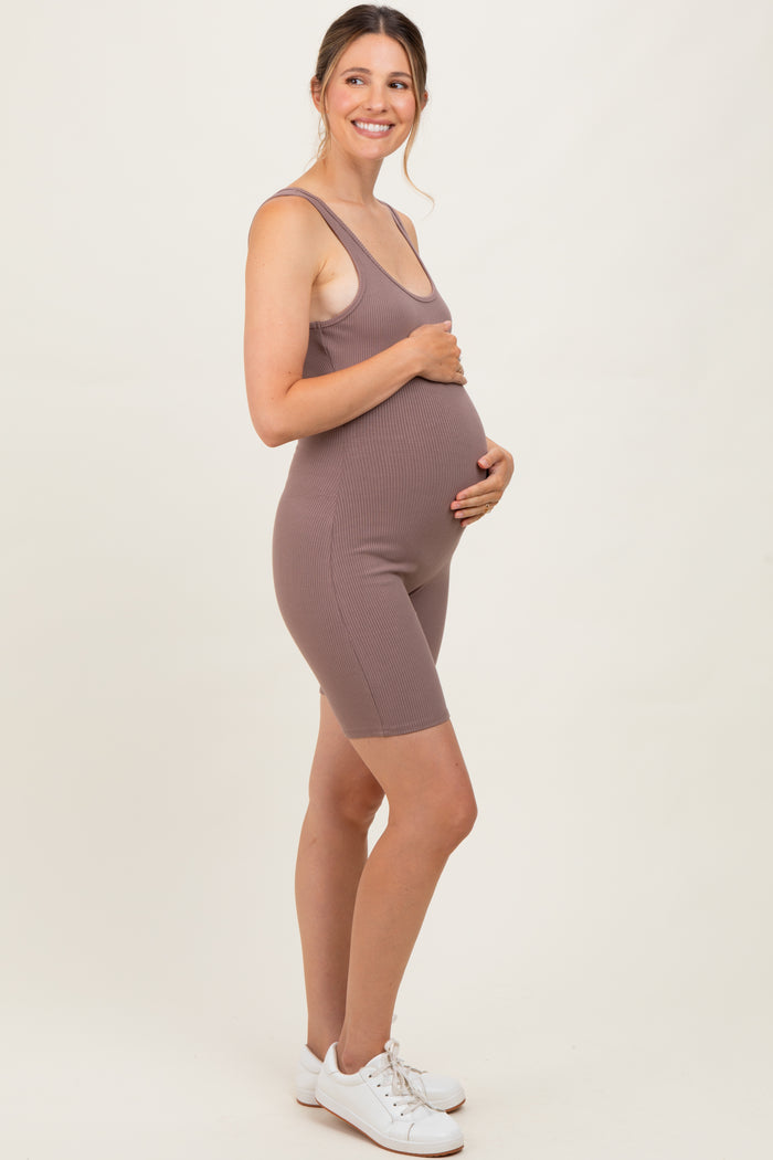 woman wearing a mauve ribbed maternity bodysuit, smiling and holding her baby bump