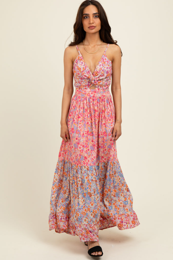 woman wearing a pink and blue floral maxi dress with a tie front and adjustable straps
