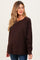 woman wearing a brown long sleeve maternity top with a relaxed fit and visible baby bump