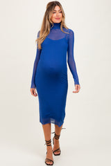 woman wearing a blue maternity dress with a sheer long sleeve and a fitted silhouette, showing her baby bump