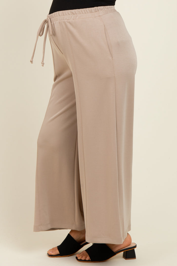woman wearing beige maternity wide-leg pants with an elastic waistband and drawstring