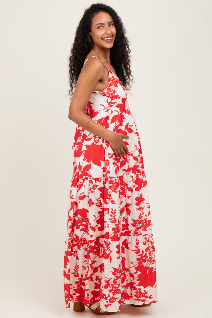 woman wearing a red and white floral maternity maxi dress and holding her baby bump