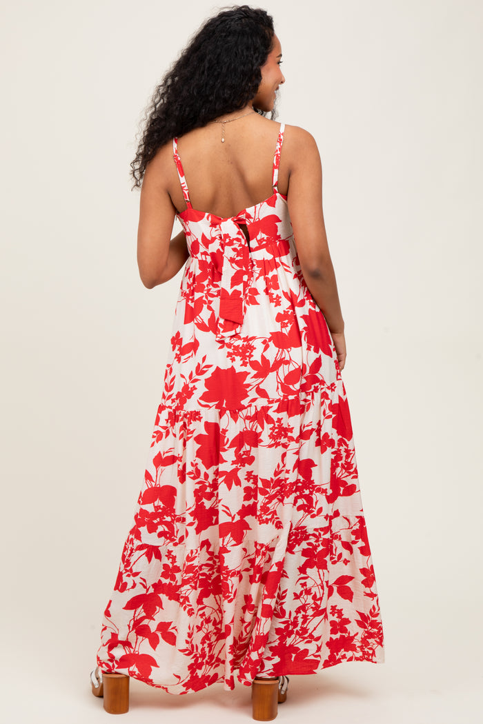 woman wearing a red and white floral maxi maternity dress, with adjustable spaghetti straps and a flowy design