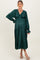 woman wearing a dark green maternity dress with a v-neck and tiered design, showcasing her baby bump
