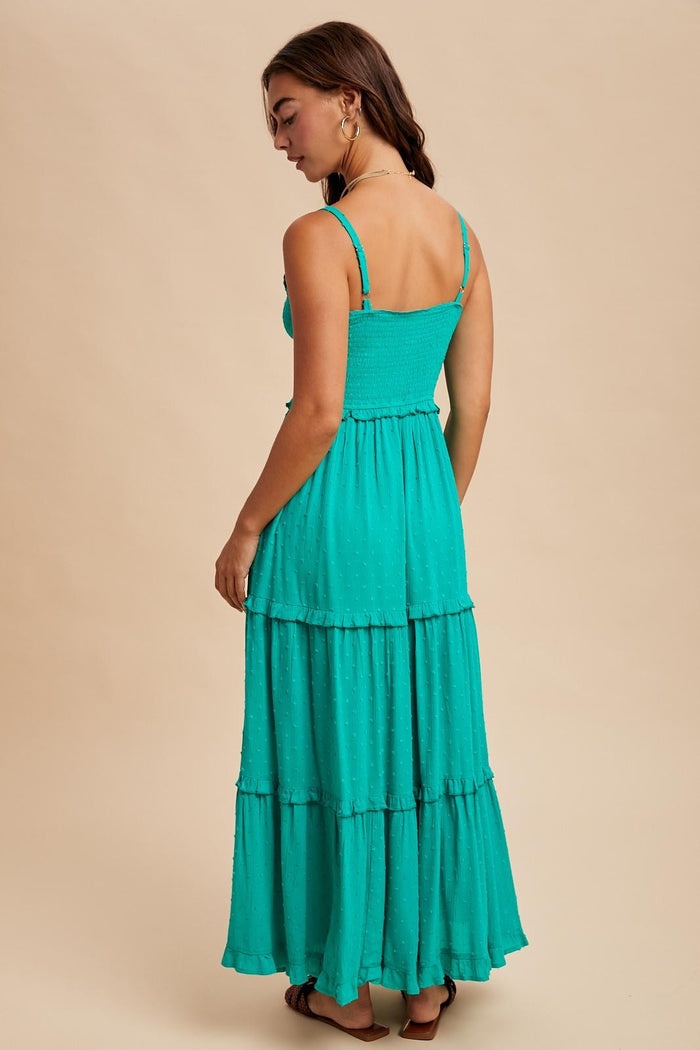 woman wearing a teal tiered maxi dress with thin straps and a smocked bodice, viewed from the back