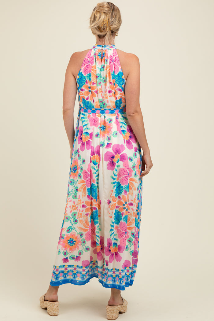 woman wearing a floral print maternity maxi dress with a halter neckline, showing the back view